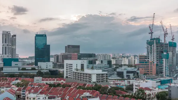 Çin Mahallesi 'nin kırmızı çatıları ve Merkezi İş Bölgesi gökdelenleri, Singapur. Eski ve modern binalar arasındaki zıtlık. İnşaat alanı ve gün batımından önce caddelerde trafik