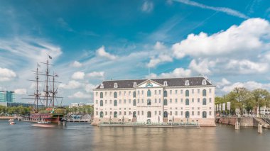 Denizcilik Müzesi 'nin hiperlapse' si ve Amsterdam 'ın deniz kenarı kopyası. Bulutlu mavi gökyüzü. Kültürel aktiviteleri, kanalları ve köprüleri meşhurdur. Amsterdam, Hollanda