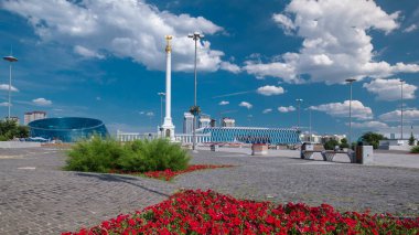 Yıldız heykeli Kazak Eli 'ın kuş Samruk ve Bağımsızlık Sarayı' nın zaman atlaması ve kırmızı çiçek tarhı ön planda. Nur-Sultan şehri, Kazakistan