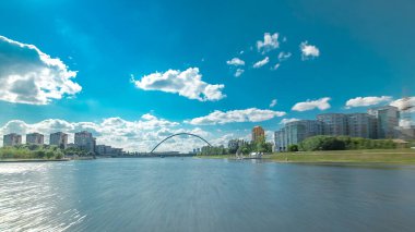 Astana, Kazakistan. Keyif teknesinden Astana 'da Ishim nehrinde hareketli bir seyahat görüntüsü. Mavi gökyüzü ve bulutlarla dolu bir yaz gününde. Bulanık hareket