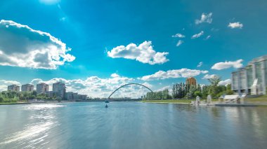 Astana, Kazakistan. Keyif teknesinden Astana 'da Ishim nehrinde hareketli bir seyahat görüntüsü. Mavi gökyüzü ve bulutlarla dolu bir yaz gününde. Bulanık hareket