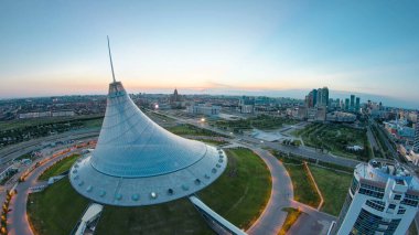 Khan Shatyr ve merkez iş bölgesiyle şehir merkezinin üzerindeki hava manzarası. Gün doğumundan önce geçiş zamanı, Kazakistan, Astana, Orta Asya
