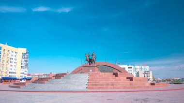 Timelapse Hiperlapse Kazak Kahramanlar Anıtı Makhambet Utemisov ve Isat 'ın Atyrau Şehrinde. Güneşli bir günde Kazakistan 'da Mavi Bulutlu Gökyüzüne karşı haraç açılır