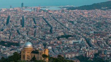 Barcelona 'nın panoraması Tibidabo Dağı' nın tepesinde gün batımından önce sarayla birlikte. Katalonya, İspanya. Gölge şehrin üzerinde hareket ediyor.