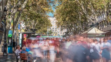 La Rambla Revelry: İspanya 'daki Iconic Barcelona Caddesi' nin Zaman Kaynağı. Binlerce insan bu hareketli yaya barınağından her gün geçerek canlı ve kalabalık bir atmosfer yaratıyor.