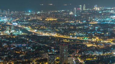 Ev ve trafik gece timelapse çatılar ile Barcelona ve Badalona manzarası. Tepenin üstüne Iberic Puig İspanya köyü açısından havadan görünümü