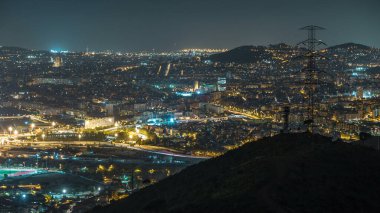 Evler ve ufuk gece timelapse denizde çatılar ile Barcelona ve Badalona manzarası. Tepenin üstüne Iberic Puig İspanya köyü açısından havadan görünümü