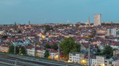 Tren istasyonu yakınlarındaki Schaerbeek 'te Brüksel ufuk çizgisi üzerinde hava gününden geceye geçiş zamanı panoraması. Konut blokları, Saint-Servais Kilisesi ve belediye binası Belçika 'nın kırmızı çatılarıyla çevrili.