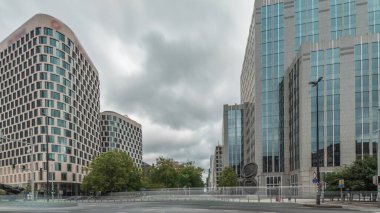 Baudouin Bulvarı, Brüksel, Belçika 'daki iş bölgesi zaman çizelgesinde trafik ve modern ofis binalarını gösteren panorama. Kavşağın yanındaki çağdaş kuleler bulutlu bir gökyüzünün altına park ederler.