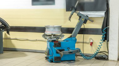 Profesyonel araba tamircisi otomobil tamir servisinin zaman ayarında tekerleği değiştiriyor. Makine dengeleyicisi ile dengeleyici tekerlek hizmet.