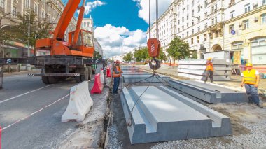 Vinç yol inşaat site timelapse hyperlapse, beton plaka yükleme. Kavganın ve üniforma ile sanayi işçileri. Sokak şehir tramvay yeniden inşası izler
