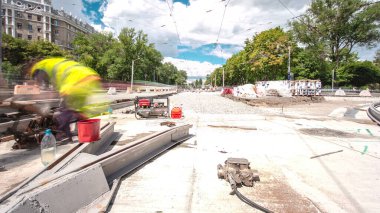 Tramvay rayları onarımı ve bakım zamanı olan bir yol inşaatı. Şehir caddesinde yeni raylar kesiyorum. Kavşağın ortası. Yeni toplu taşıma için demiryolu raylarının değiştirilmesi