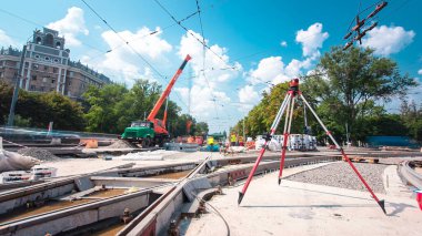 Tramvay rayları onarılan ve hiperhızlandırılmış yol inşaatı. Kavşağın ortasındaki tripodun elektronik seviyesi. Yeni toplu taşıma için demiryolu raylarının değiştirilmesi