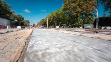 Beton yol yapım Tekdüzen timelapse işçi ile çalışır. Kaplama ve koruyucu filtre püskürtücü tarafından. Tramvay parça yeniden inşası