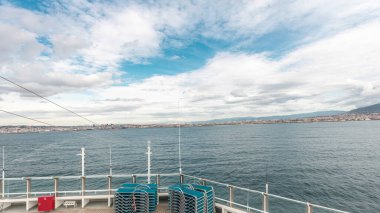 Dalgalı deniz manzarası ve açık deniz zaman diliminde yelken açan gemiden liman manzarası. Napoli kıyısı, İtalya