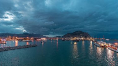 Gün batımından sonra açık denizde seyreden dalgalı ve limanlı deniz manzarası. Palermo kıyısı, İtalya