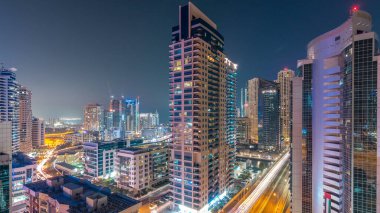 Dubai Yat Limanı hava görünümünü gece geçiş timelapse için bir noktadan günden güneş battıktan sonra. Modern gökdelenler ve konut kuleleri de akşam aydınlatılmış. Köprüde trafik