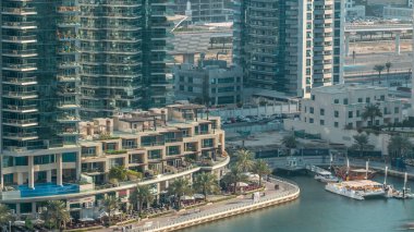 Lüks Dubai Yat Limanı kanal geçen tekneler ile ve avuç içi timelapse ile promenade, üst görüntülemek üzerinden yukarıda akşam gün batımına. Dubai, Birleşik Arap Emirlikleri