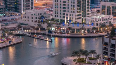 Geçen tekneler ve avuç içi gün gece ile promenade ile lüks Dubai Yat Limanı kanal timelapse geçiş, yukarıdan bakışta akşam güneş battıktan sonra Top. Dubai, Birleşik Arap Emirlikleri