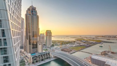 JBR ve Dubai marina günbatımı hava timelapse sırasında. Modern kule ve gökdelen, Rating köprüde, yatlar ve kanalda yüzen tekne