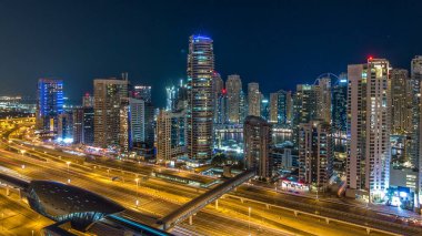 Dubai Yat Limanı timelapse fantastik çatı manzarası. Işıklandırılmış gökdelenler büyük bir şehrin gece, Birleşik Arap Emirlikleri. Hava Jlt görünümünden