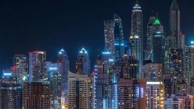 Dubai Yat Limanı timelapse fantastik çatı manzarası. Büyük bir şehrin gece, Birleşik Arap Emirlikleri tarafından aydınlatılmış en yüksek gökdelenler. Hava Jlt görünümünden