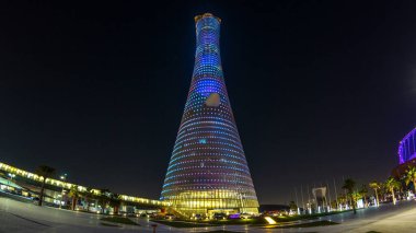 Gece Doha Spor Şehri 'ndeki Aspire Kulesi ya da Torch Hotel zaman tüneli. Doha, Katar, Orta Doğu. Aydınlatılmış gökdelen