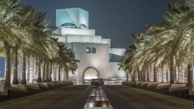 İslam Sanatları Müzesi, Katar 'ın Doha kentindeki çeşme zaman ayarlarıyla geceleyin aydınlandı. Avuçlar yana. İslam eserlerinin en eksiksiz koleksiyonlarından biri.