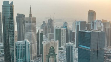 Günbatımından önce gökdelenler başkent Katar 'ın ticaret merkezi Doha' nın ufuk çizgisinde. Sisli havada hava manzarası. Yolda trafik vardı.