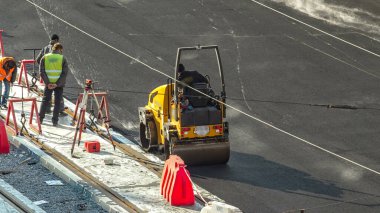 Yeni yol inşaatında çalışan yol silindirlerinin geniş bir manzarası var. Görünümü asfaltlama çalışmaları ile kapat