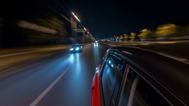 Hızlı arabanın yanından gelen bir saçmalık. Bir gece caddesinde hızla ilerliyor. Işıklar yüksek hızda arabaya yansıyor. Modern bir şehrin hızlı ritmi. Bulanık hareket