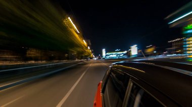 Hızlı arabanın yanından gelen bir saçmalık. Bir gece caddesinde hızla ilerliyor. Işıklar yüksek hızda arabaya yansıyor. Modern bir şehrin hızlı ritmi. Bulanık hareket