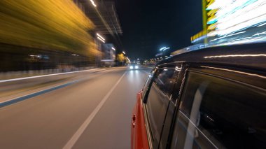 Hızlı arabanın yanından gelen bir saçmalık. Bir gece caddesinde hızla ilerliyor. Işıklar yüksek hızda arabaya yansıyor. Modern bir şehrin hızlı ritmi. Bulanık hareket
