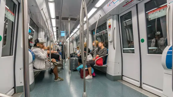 Urban Transit Tempo: Metro ile Giden Gidenler Gibi Modern Bir Metro Aracının İçinde Zaman Kaynağı. Dinamik Ebb ve Akış Yolcuları Şehir Hareketliliğinin Kalbindeki Yolculuklarına Yükleme ve Çıkarma