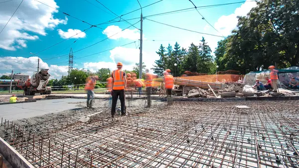 Tramvay rayları onarılan ve bakım süreleri yüksek olan yol inşaatı. Metal bir şebekede mikserden beton dökülüyor. Kavşağın ortası..