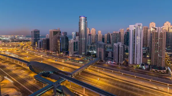 Dubai Yat Limanı gökdelenler hava üstten görünüm güneş doğmadan önce Jlt gelen Dubai gece gün timelapse, Birleşik Arap Emirlikleri için. Işıklı modern kuleleri ve Şeyh zayed yolu üzerinde trafik.