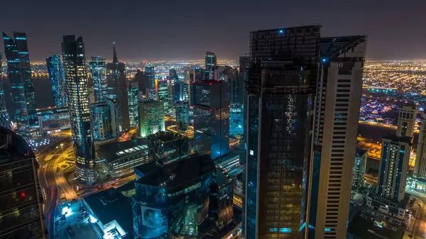 Katar 'ın Doha Zaman Çizelgesi' nde Batı Körfezi bölgesinin ufuk çizgisi. Aydınlatılmış modern gökdelenler geceleri çatıdan gökyüzü manzarası