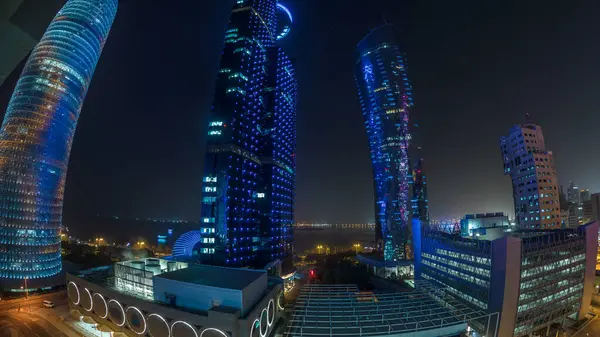 Katar 'ın Doha Zaman Çizelgesi' nde Batı Körfezi bölgesinin ufuk çizgisi. Aydınlatılmış modern gökdelenler geceleri çatıdan gökyüzü manzarası. Arka plandaki körfez ve yoldaki trafik