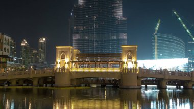 Burj Halife ile köprü ve çeşmeler su gecesine yansıyor panoramik zaman dilimi, Dubai, Emirlikler 'de ışıklar yanıyor