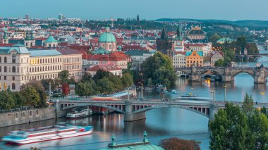 Prag 'daki Vltava Nehri' nin hava akşam manzarası ve trafik ile aydınlanan köprüler. Kuleler ve kuleler. Tekneler ve gemi suda yüzüyor. Hanavsky köşkünden üst görünüm