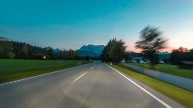 Avusturya, bir güzel sonbahar günü timelapse hyperlapse drivelapse Alpler'de asfalt yolda sürücü. Orman ve dağlar akşam