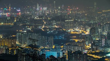 Fei ngo Shan Kowloon Tepesi 'nden hava görüntüsü. Gece zaman çizelgesi Hong Kong şehrinin gökyüzü. Yukarıdan aydınlatılmış binalar ve elektrik nakil hatları