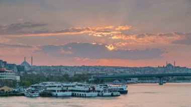İstanbul 'un ufuk çizgisi İstanbul' da, günbatımında Boğaziçi ve Altın Boynuz 'daki tekne istasyonu yakınlarında çok sayıda yolcu feribotu bulunuyor. Arka planda cami ve köprü, bahar akşamında suyun yansımasıyla