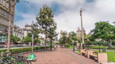 Jose Larco Bulvarı 'nda kırmızı bisiklet pisti ve Miraflores, Lima Peru' da bisiklet parkında hız sınırı. Central Park sağda ve caddede trafik var.