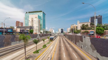 Via Expresa otoyolu ve trafikle dolu metropolitan otobüsün hava manzarası ve bulutlu mavi gökyüzü. Arka planda gökdelenler. Lima, Peru