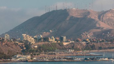 Lima 'nın Sahil şeridi ile Morro Solar Hill' in arka plan zaman çizelgesi, Lima, Peru. Yatlı liman ve okyanuslu plaj. Circuito de Playas yolunun yakınındaki uçurumdan görünüm