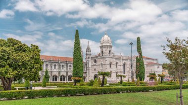 Mosteiro dos Jeronimos ve bahçede çimenliği olan yeşil ağaçlar, Lizbon, Portekiz 'in Belem bölgesinin zaman diliminde yer almaktadır. Manueline tarzı (Portekizce geç Gotik). Mavi gökyüzünde bulutlar
