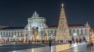 Lizbon 'daki ticaret meydanı, Noel' de yüksek bir ağaç ve geceleri kemerle aydınlandı. Dekorasyon ve tarihi mimarinin yer aldığı şenlikli atmosferin zamanlaması