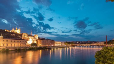 Aziz John 'un Vaftizci Katedrali ve Lyon' daki Notre-Dame de Fourviere Bazilikası 'nın zaman çizelgesi, günden geceye değişiyor. Yansıtılmış rıhtım ve nehirde yansıyan binalar. Fransa