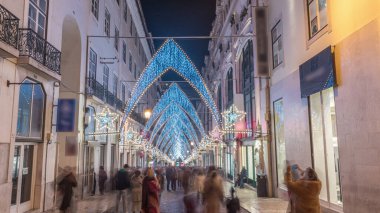 Lizbon şehir merkezindeki Chiado Carmo sokağındaki Noel ışıkları ve dekorasyonları gece aşırı hızlandı. İnsanlar aydınlanmış kemerlerin altında yürürler. Portekiz 'de festival dekorlu tatil atmosferi
